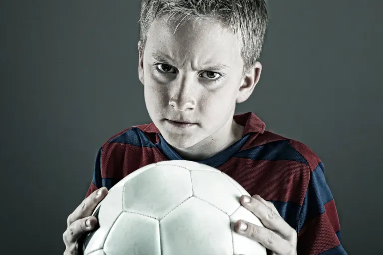 Child playing football, illustrating growth mindset in sport and resilience