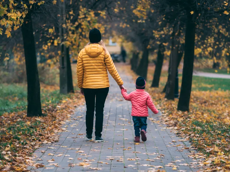 Child showing separation anxiety at school drop-off, clinging and distressed