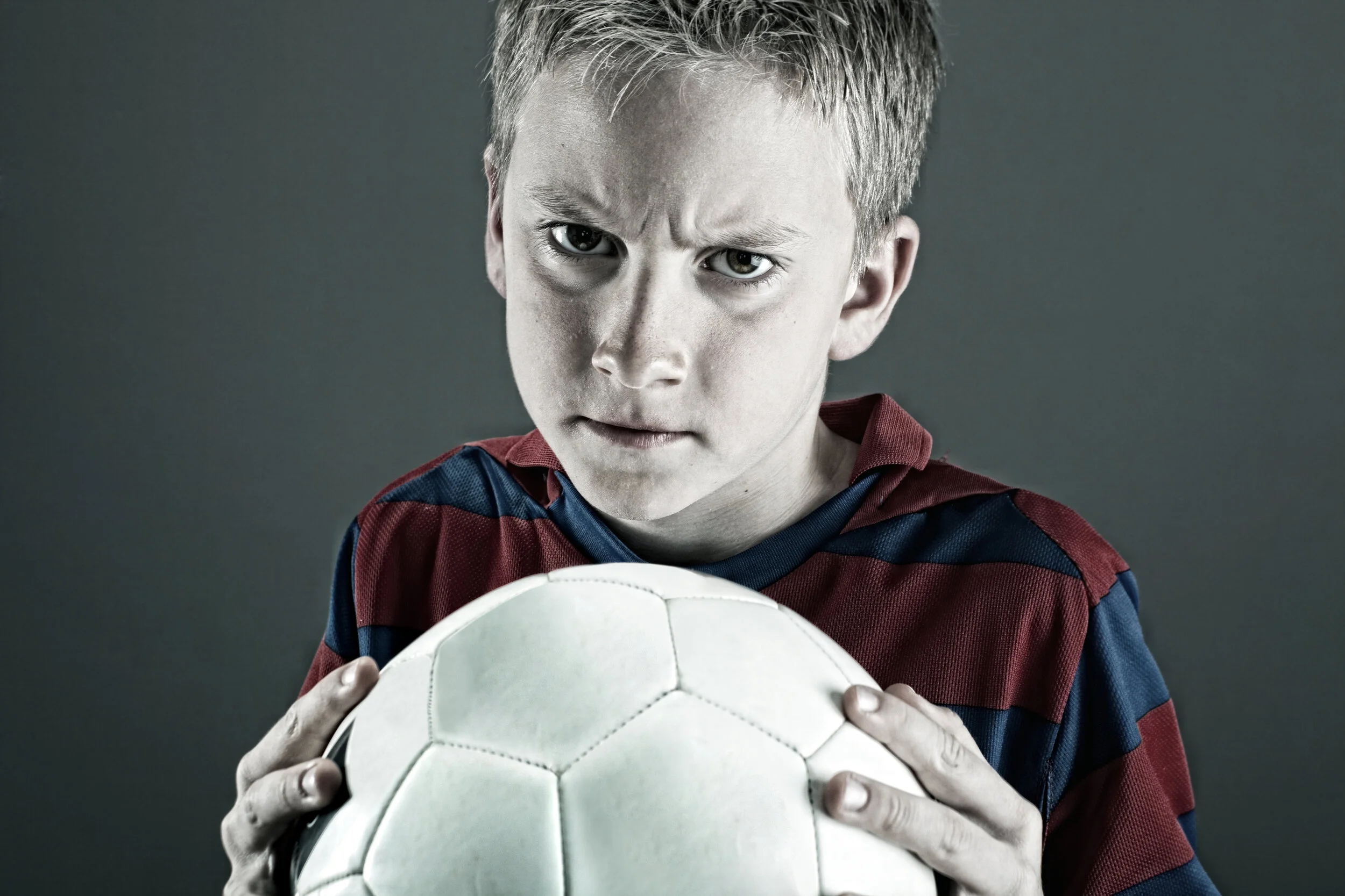Child playing football, illustrating growth mindset in sport and resilience